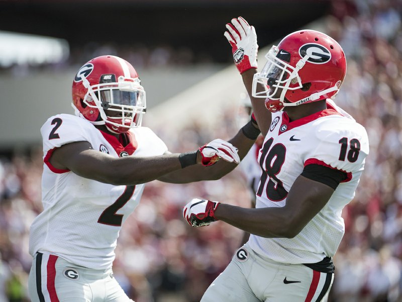 Georgia defensive back Deandre Baker (18) and Richard LeCounte (2) celebrate a defensive play against South Carolina during the first half of an NCAA college football game Saturday, Sept. 8, 2018, in Columbia, S.C. (AP Photo/Sean Rayford)