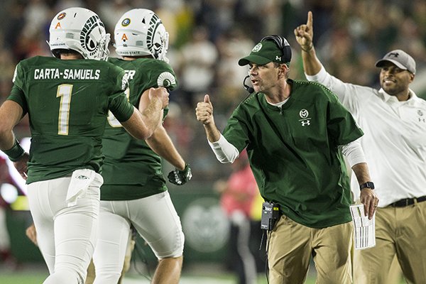 Mike Bobo, Colorado State head coach, fist bumps quarterback K.J. Carta-Samuels after a touchdown in the 4th quarter vs Arkansas Saturday, Sept. 8, 2018, at Canvas Stadium in Fort Collins, Colo.