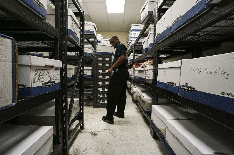 Sgt. Billy Bradley takes a look at the damage to case files Sunday after overnight flooding inundated the Pine Bluff Police Department.