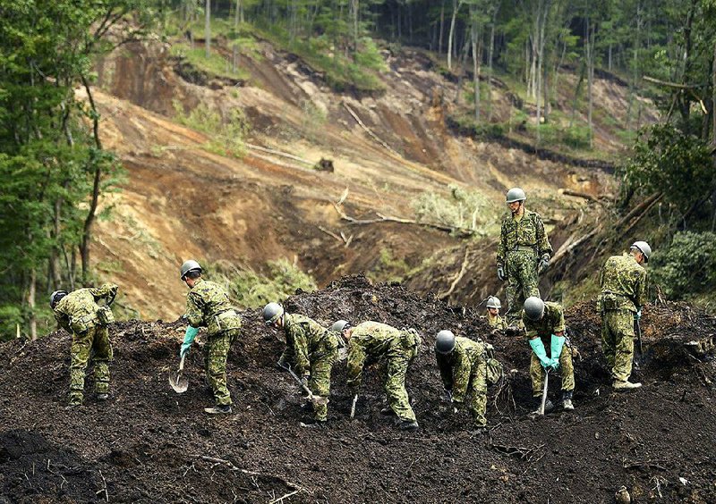 Japan’s self-defense force members work at the site of a land- slide triggered by Thursday’s earthquake in Atsuma, Hokkaido, northern Japan on Sunday.