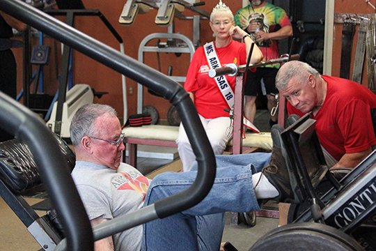 Eighty five year-old Harold Hager leg presses 400 lbs during the weightlifting competition during the Arkansas Senior Olympics as Joe Bill Morton and Ms. Senior Arkansas Dixie Ford look-on on Friday September 7. (The Sentinel-Record/Rebekah Hedges)