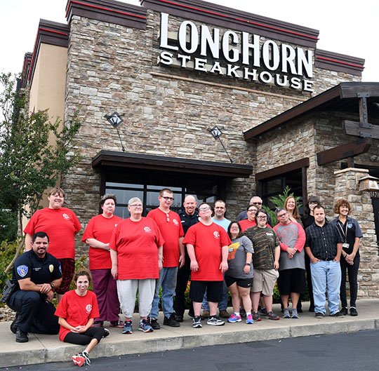 The Sentinel-Record/Grace Brown- Members of the Hot Springs Police Department, Abilities Unlimited Hot Springs, Civitan Services of Bryant, and LongHorn Streakhouse staff have their photo taken on Thursday, September 6, 2018, in front of the steakhouse to promote their Tip a Hero event held on Thursday, September 13, 2018. 