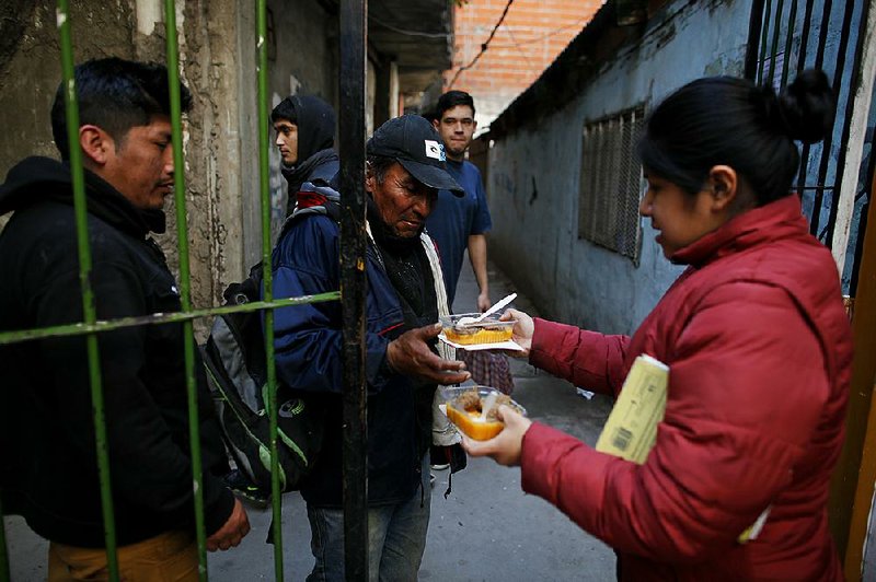People line up Thursday for a meal outside a soup kitchen at a community center in Buenos Aires, Argentina. The country’s economy is in a crisis and analysts say poverty, which affects about a third of the population, is expected to rise this year.