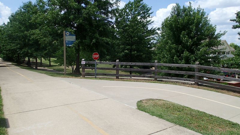 NWA Democrat-Gazette/FLIP PUTTHOFF Blossom Way Trail, seen at right, veers off the Razorback Greenway 1.7 miles south of the Mercy trailhead in Rogers. A bike ride from Mercy trailhead to downtown Rogers on Blossom Way Trail 8.5 miles one way.