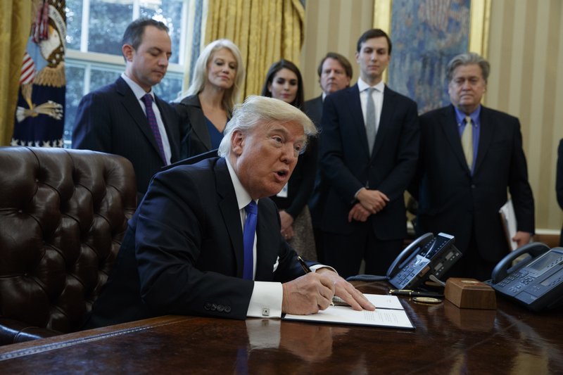 FILE - In this Jan. 24, 2017, file photo, President Donald Trump signs an executive order on the Keystone XL pipeline in the Oval Office of the White House in Washington. Native American tribes in Montana and South Dakota say the Trump administration unlawfully approved the Keystone XL oil pipeline without considering potential damage to cultural sites. Attorneys for the Fort Belknap and Rosebud Sioux tribes sued the U.S. State Department Monday, Sept. 10, 2018, asking a court to rescind the permit. (AP Photo/Evan Vucci, File)