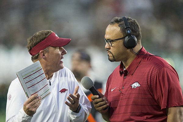 Arkansas coach Chad Morris (left) talks to Razorback Sports Network reporter Geno Bell during a game against Colorado State on Saturday, Sept. 8, 2018, in Fort Collins, Colo.