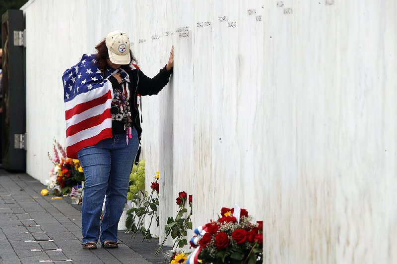 Chrissy Bortz of Latrobe, Pa., stands at the Wall of Names at the Flight 93 National Memorial in Shanksville, Pa., after a service marking the 17th anniversary of the Sept. 11, 2001, terrorist attacks. Similar services were held at ground zero in New York and at the Pentagon. In a string of morning tweets, President Donald Trump, who took part in the Pennsylvania service, interspersed messages about Sept. 11 with criticism of the FBI and the Justice Department. 