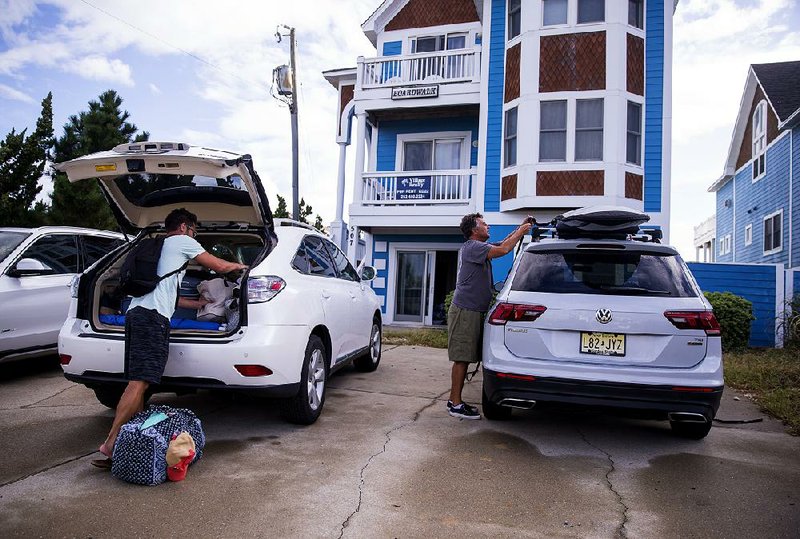 People pack up Tuesday in the Outer Banks area of North Carolina after an evacuation order by Gov. Roy Cooper. 
