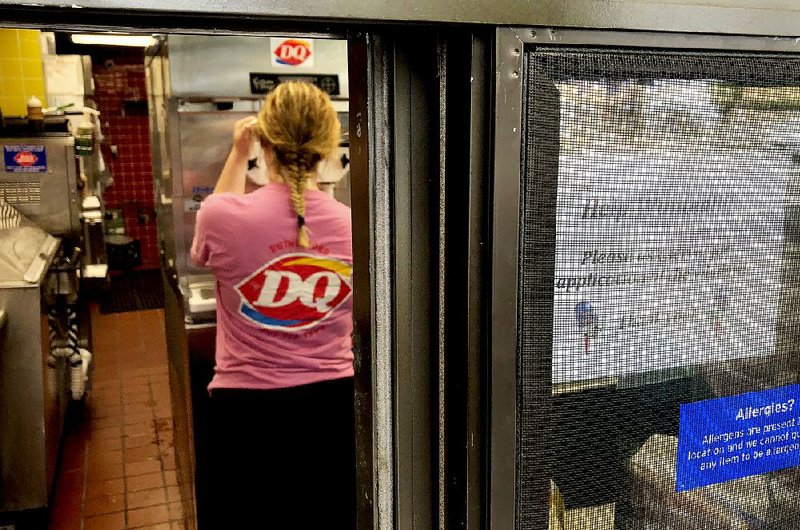 A worker prepares a cup of ice cream behind a “Help Wanted” sign at a Dairy Queen restaurant in Rutherford, N.J., in August. U.S. employers advertised a record 6.9 million job openings in July, and the number of workers quitting their jobs hit 3.58 million, the Labor Department reported Tuesday. 