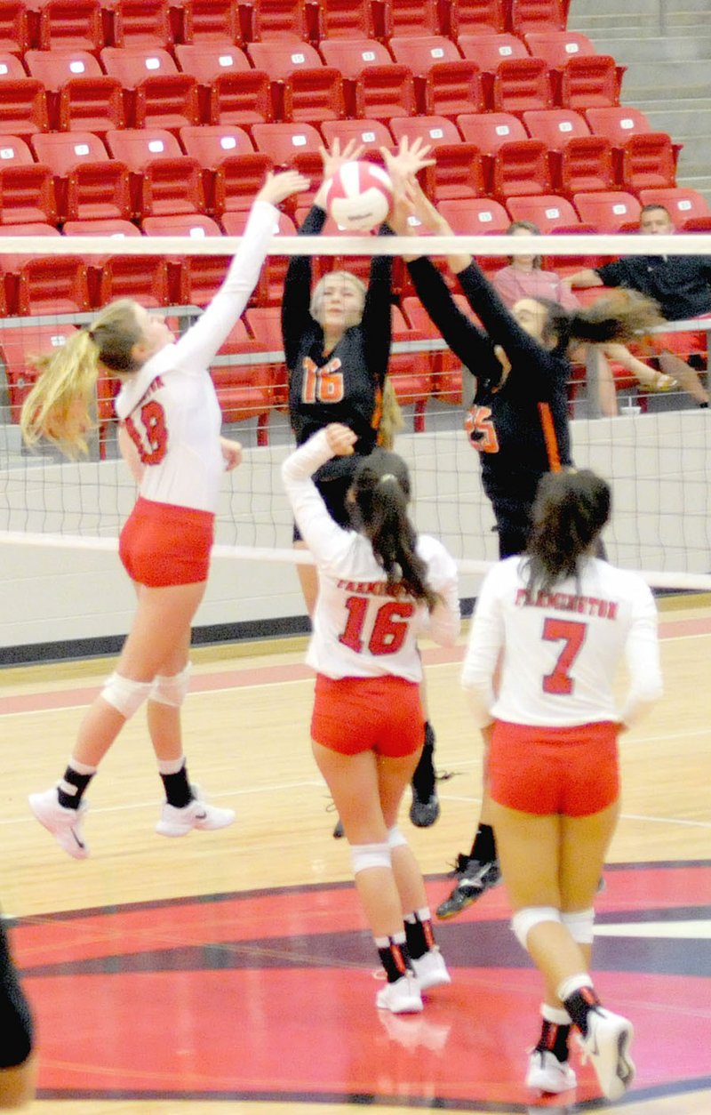 MARK HUMPHREY ENTERPRISE-LEADER Farmington junior Brittany Pittman attacks at the net against the attempted block of Gravette's Allie Callahan and Olivia Perry while Farmington's Eliza Ball and Anthea Jones stand ready to help. The Lady Cardinals defeated Gravette 25-23, 25-18, 25-17 Thursday, Sept. 6, 2018, at Cardinal Arena.