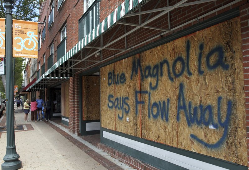 Storefronts have wood paneling installed over windows, Tuesday, Sept. 11, 2018, in New Bern, N.C., as a precaution against storm damage from Hurricane Florence. (Gray Whitley/Sun Journal via AP)