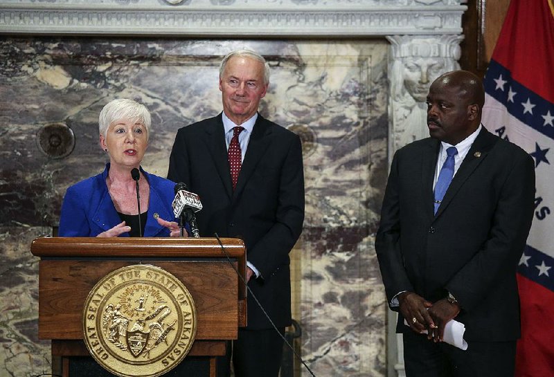In this file photo Arkansas Human Services Director Cindy Gillespie talks about the people who lost health coverage under Arkansas Works because they failed to comply with the program’s new work requirement conditions. Gov. Asa Hutchinson (center) and Workforce Services Director Daryl Bassett also spoke. 