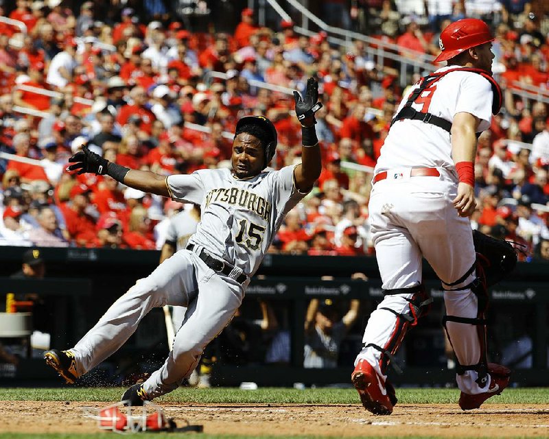 Pablo Reyes (left) of the Pittsburgh Pirates slides past St. Louis Cardinals catcher Carson Kelly during the Pirates’ 4-3 victory over the Cardinals on Wednesday at Busch Stadium in St. Louis.
