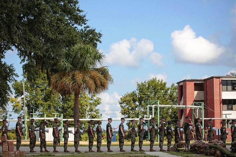New recruits line up Tuesday to leave the Marine Corps Recruit Depot at Parris Island in South Carolina. While some nonessential personnel and families were moved off the base, most of the more than 8,000 Marines and support staff members are staying. 

