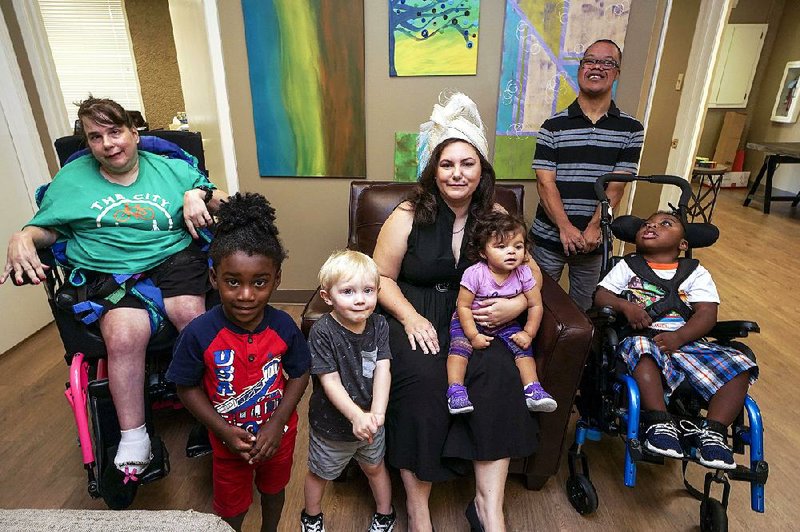 United Cerebral Palsy board member Amy Green, surrounded by clients, wears a hat that will be auctioned off Sept. 25 at Once Upon a Time. The hat was once owned by Willie Oates, a longtime UCP board member. After her death in 2008, her family donated a collection of hats to UCP. 