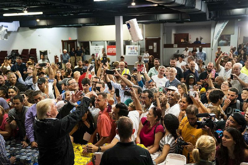 President Donald Trump tosses supplies at a relief center in Guaynabo, Puerto Rico, on Oct. 3, during his visit to view the damage and recovery efforts after Hurricane Maria struck the island. 