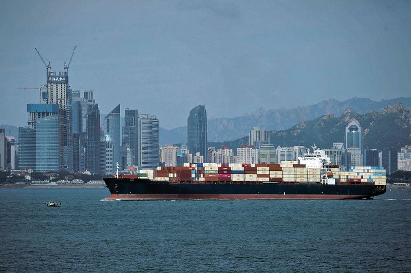 A container ship sails past the business district in Qingdao, China. President Donald Trump’s tweet Thursday regarding trade talks with China ruffled the equities markets. 