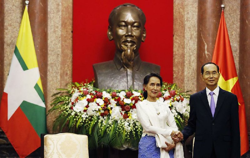 Aung San Suu Kyi is greeted Thursday by Vietnamese President Tran Dai Quang at the presidential palace in Hanoi.