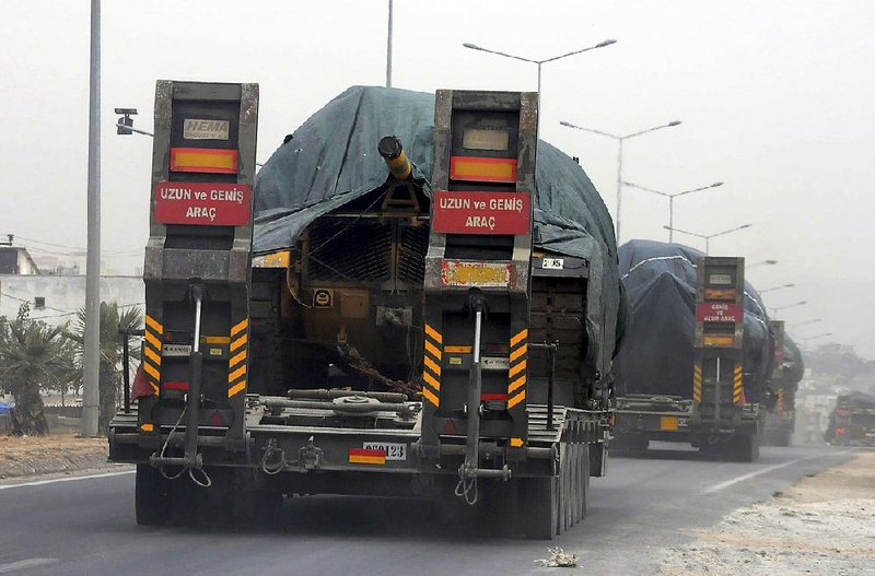 A Turkish forces convoy of trucks carrying tanks destined for Syria travels near the town of Reyhanli, Turkey, on Thursday.