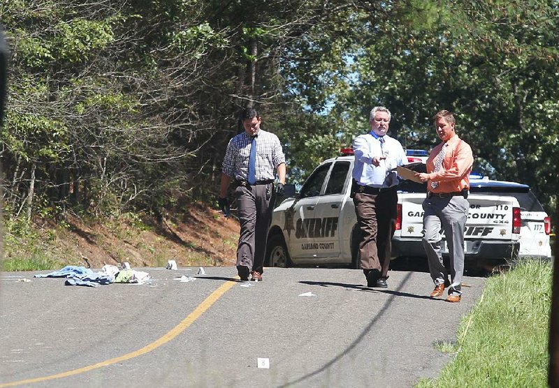 Garland County Investigator Brandon Huckaba, left, Investigator Randy Rowe and Cpl. Kenny Ford investigate the scene where a minor girl was found shot Thursday, September 13, 2018. The vicim was airlfted by LifeNet to Little Rock for treatment. (The Sentinel-Record/Richard Rasmussen)