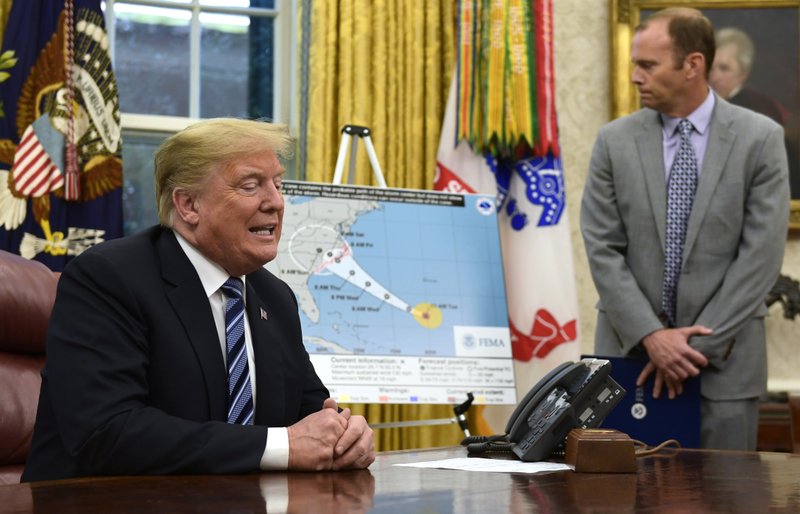 President Donald Trump, left, talks about Hurricane Florence during a briefing in the Oval Office of the White House in Washington, Tuesday, Sept. 11, 2018, as FEMA Administrator Brock Long listens at right. (AP Photo/Susan Walsh)