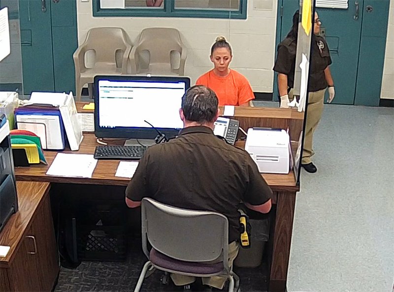This photo from video released Thursday, Sept. 13, 2018, by the Kaufman County sheriff's office in Kaufman, Texas, shows Dallas police Officer Amber Guyger getting booked after surrendering Sunday, Sept. 9, after the fatal shooting of Botham Jean in his own apartment. 