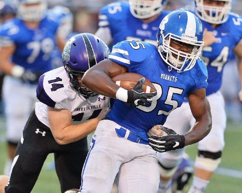 Bryant’s Ahmad Adams (35) is tackled by Fayetteville’s Luke Charboneau during Friday night’s game at Bryant.