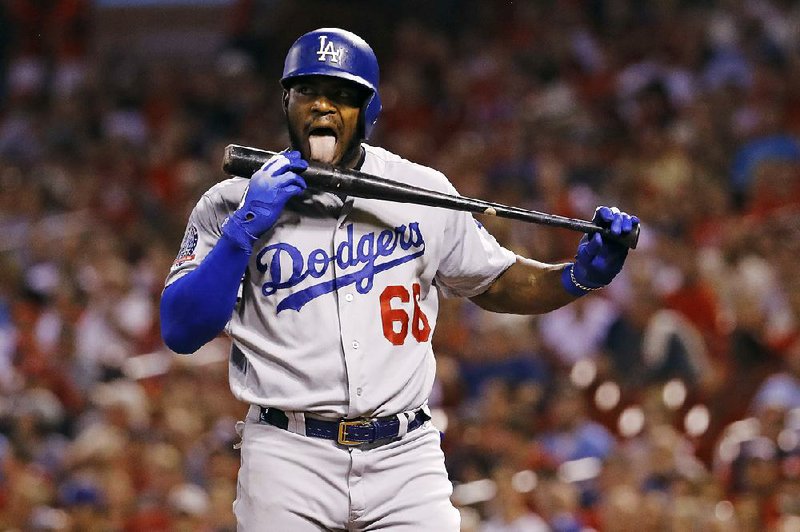 Yasiel Puig of the Los Angeles Dodgers licks his bat as he heads to the plate in St. Louis in the first inning of Friday night’s game against the St. Louis Cardinals. Puig homered in the at-bat and the Dodgers won 3-0.