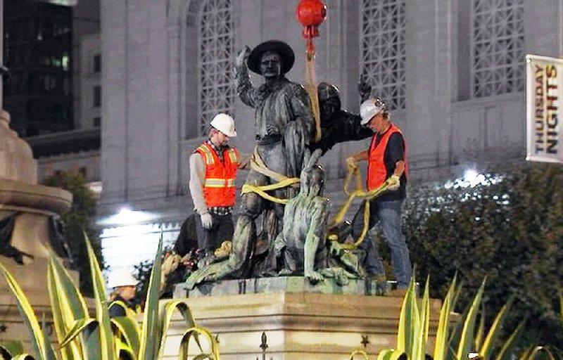 An image from video shows crews in San Francisco on Friday removing a statue that some have called racially offensive and demeaning to indigenous people. 