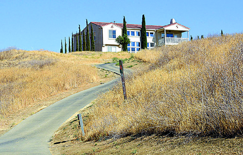 Dry grass surrounds a home in the Diablo Grande gated community west of Patterson, Calif., earlier this month.  