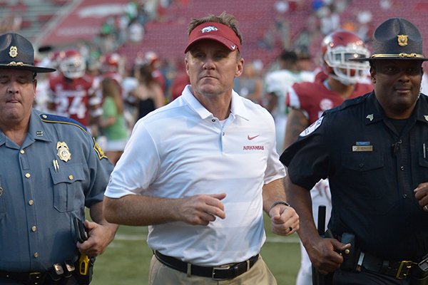 Arkansas coach Chad Morris is escorted off the field after the Razorbacks' 44-17 loss to North Texas Saturday, Sept. 15, 2018, at Razorback Stadium in Fayetteville.
