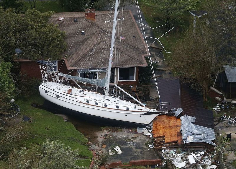 A sailboat sits between a house and a collapsed garage Saturday in New Bern, N.C. 