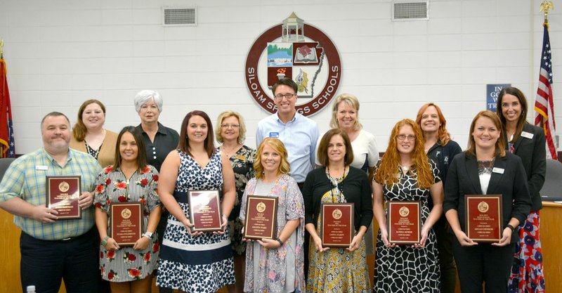 Janelle Jessen/Siloam Sunday Teachers of the year were recognized during Thursday's school board meeting. Pictured, from left, are Doug Hartman, Middle School teacher of the year; Aimee Morrell, representative of Middle School Adopters; Umia Fullerton, Northside Elementary School teacher of the year; Debi Selby, Northside Elementary School Adopters representative; Keli Sumter, Intermediate School teacher of the year; Nena Houston, Intermediate School Adopters representative; Amanda Ward, Allen Elementary School teacher of the year; Bobby Reed, Allen Elementary School Adopters representative; Lanna Hardy, Main Street Academy teacher of the year; State Rep. Robin Lundstrum (R-District 87), Main Street Academy Adopters representative; Alishia Morris, Southside Elementary School teacher of the year; Patti Eiland, Southside Elementary School Adopters representative; Megan Denison, Siloam Springs High School teacher of the year; and Anne Martfeld, SSHS principal. Jake Wilmont, SSHS Adopters representative is not pictured.