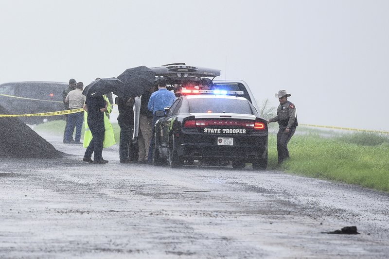 Law enforcement officers gather near the scene where the body of a woman was found near Interstate 35 north of Laredo, Texas on Saturday, Sept. 15, 2018. A U.S. Border Patrol agent suspected of killing four women was arrested early Saturday after a fifth woman who had been abducted managed to escape from him and notify authorities, law enforcement officials said, describing the agent as a &quot;serial killer.&quot; (Danny Zaragoza/The Laredo Morning Times via AP)