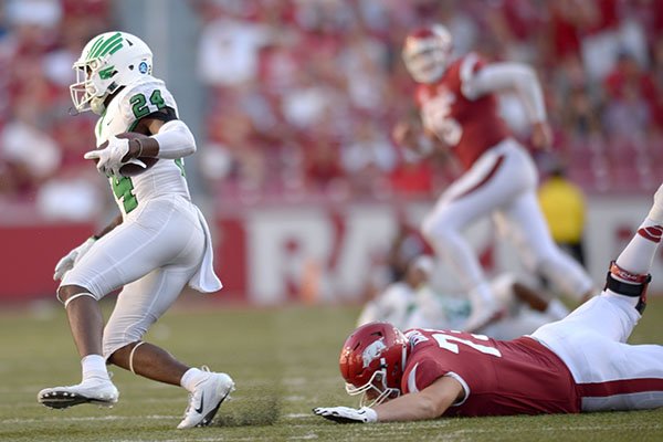 Arkansas offensive lineman Noah Gatlin (right) reaches to stop North Texas defensive back Taylor Robinson Saturday, Sept. 15, 2018, after Robinson intercepted a pass during the third quarter at Razorback Stadium in Fayetteville.