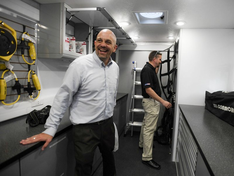 Keith Peterson (left), NWACC dean of workforce development, smiles Thursday as Joseph Stewart of ProServices at Lowe’s, tours a mobile construction lab at Lowe’s in Bella Vista. The Arkansas Department of Higher Education gave NWACC $1 million allowing the college to continue help training high school students in construction trades.