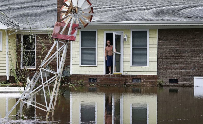 A man peers from his flooded home in Lumberton, N.C., on Sunday in the aftermath of Hurricane Florence.
