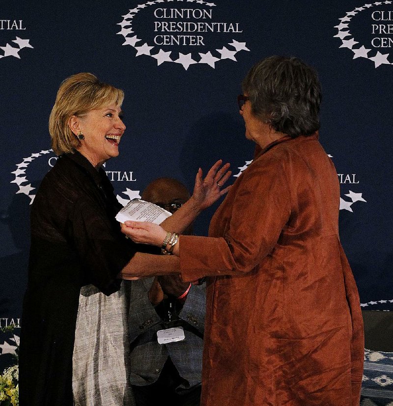 Hillary Clinton (left) gets ready to embrace Terri Garner, director of the Clinton Presidential Center, after Clinton spoke during the grand opening reception for the new Clinton center exhibit, “The White House Collection of American Crafts: 25th Anniversary Exhibit” on Sunday.