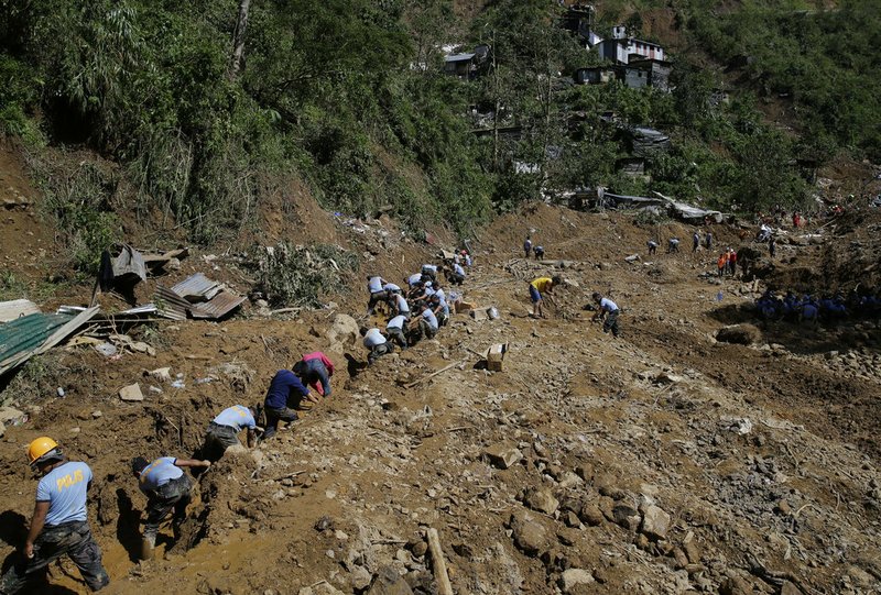 Rescuers continue to search for victims buried by a landslide after Typhoon Mangkhut lashed Itogon, Benguet province, northern Philippines on Monday, Sept. 17, 2018. Itogon Mayor Victorio Palangdan said that at the height of the typhoon's onslaught Saturday afternoon, dozens of people, mostly miners and their families, rushed into an old three-story building in the village of Ucab. The building, a former mining bunkhouse that had been transformed into a chapel, was obliterated when part of a mountain slope collapsed. (AP Photo/Aaron Favila)

