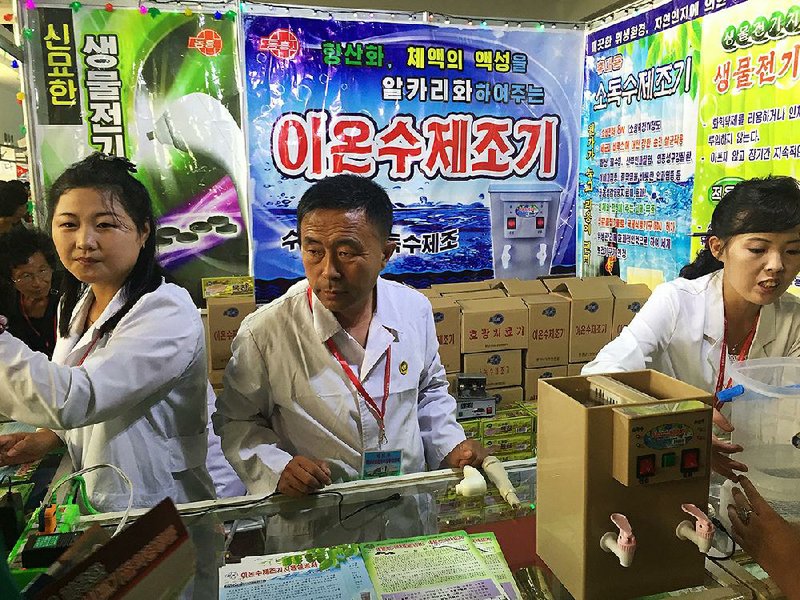 North Korean sales representatives show off water purifiers Monday at the International Trade Fair in Pyongyang, North Korea. More than 320 companies have vendors at this year’s fair, with most from North Korea or China. 