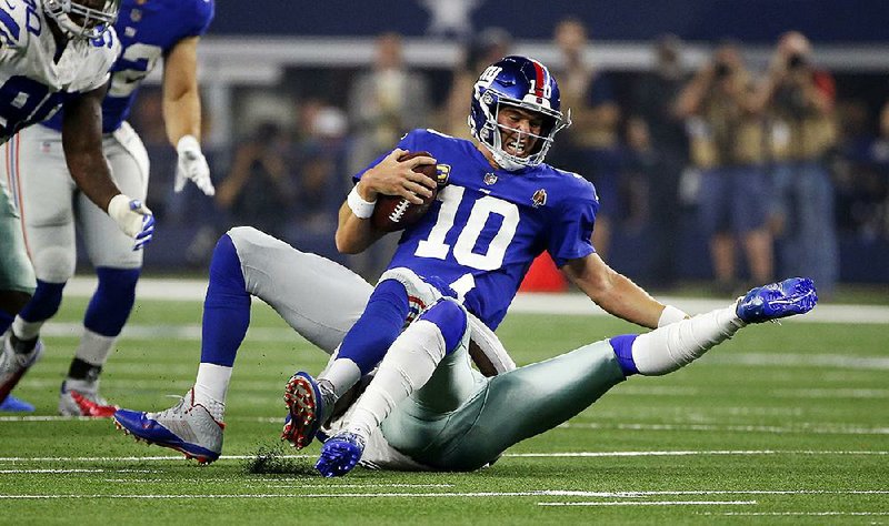 New York Giants quarterback Eli Manning is sacked for a loss by Dallas Cowboys defensive back Kavon Frazier during Sunday’s game in Arlington, Texas. Manning was sacked six times in a 20-13 loss.