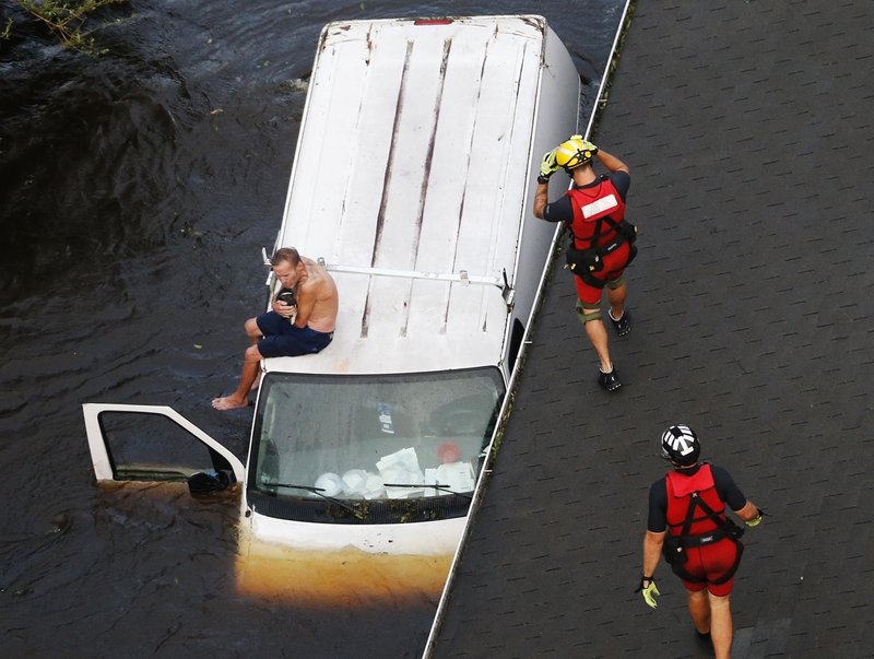 The Associated Press VAN RESCUE: U.S. Coast Guard rescue swimmer Samuel Knoeppel, center, and Randy Haba, bottom right, approach to Willie Schubert of Pollocksville, N.C., on a stranded van in Pollocksville on Monday in the aftermath of Hurricane Florence.