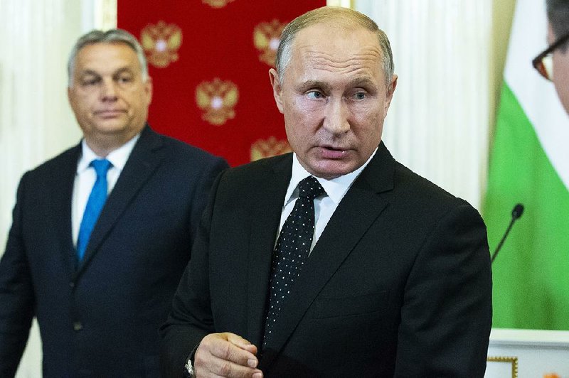 Russian President Vladimir Putin speaks to reporters Tuesday after talks with Hungarian Prime Minister Viktor Orban (left) about the downing of a Russian aircraft by a Syrian missile. 