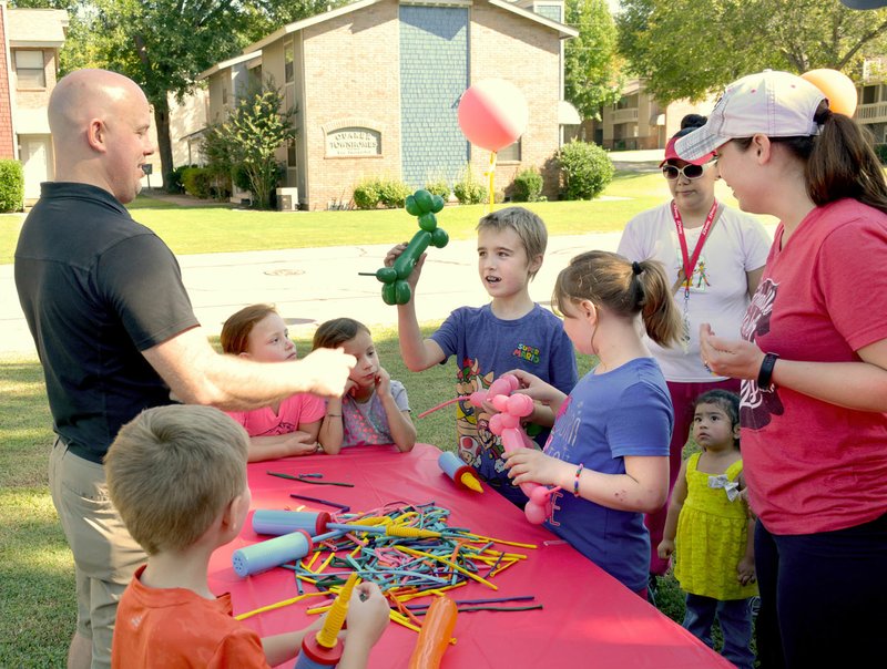 Janelle Jessen/Herald-Leader Children gathered around to have balloon animals made.