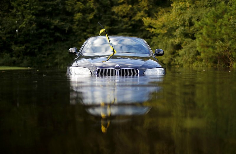 A car sits in a flooded parking lot at an apartment complex near the Cape Fear River as it continues to rise in the aftermath of Hurricane Florence in Fayetteville, N.C., Tuesday, Sept. 18, 2018. (AP Photo/David Goldman)

