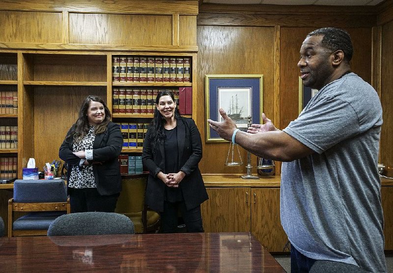 John Brown thanks two of the attorneys involved with his release, Rachel Wester (left) of the Midwest Innocence Project and Erin Cassinelli of Little Rock, in Cassinelli’s office Wednesday in Little Rock. 