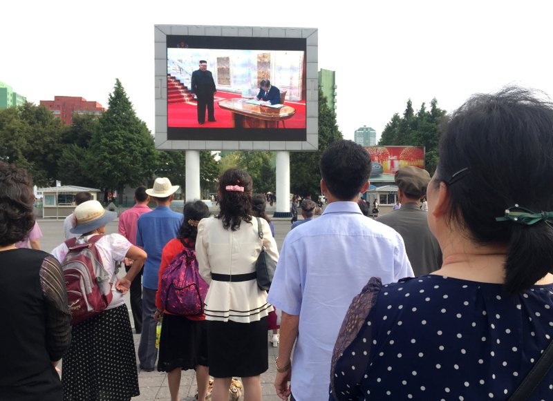 Residents of Pyongyang, North Korea gather in a plaza outside the city&#x2019;s main train station to watch the news of South Korean President Moon Jae-in&#x2019;s visit on Wednesday, Sept. 18, 2018. Though images of Moon&#x2019;s arrival had been aired around the world the day before, the first footage was delayed by a day in the North. (AP Photo/Eric Talmadge)