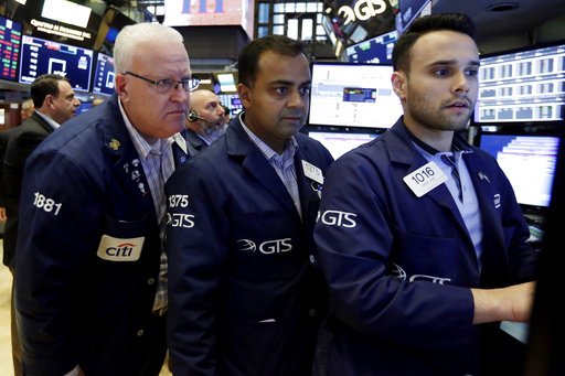 In this Aug. 31, 2018, file photo trader Thomas Ferrigno, left, works with specialists Dilip Patel, center, and Karan Virdi on the floor of the New York Stock Exchange.  (AP Photo/Richard Drew, File)