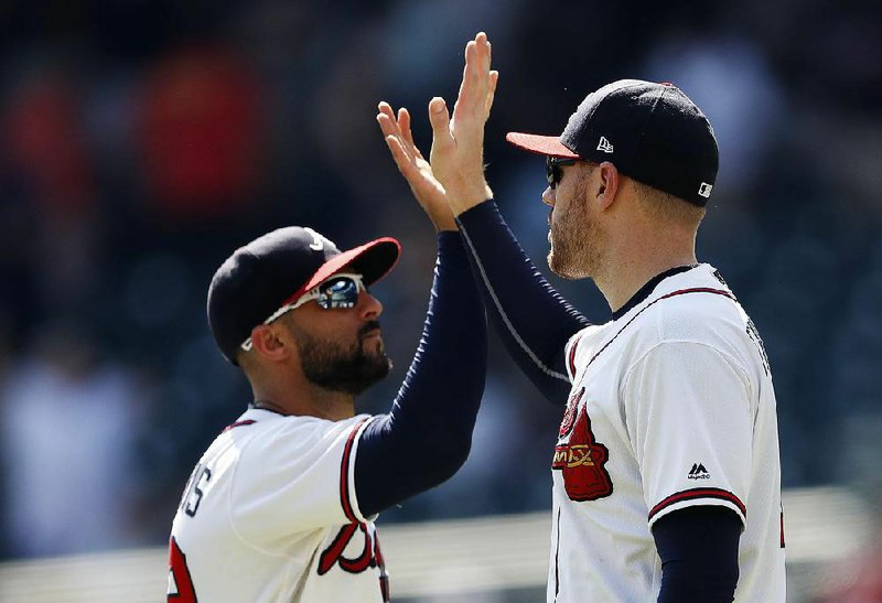 First baseman Freddie Freeman (right) and right fielder Nick Markakis celebrate after the Atlanta Braves defeated the St. Louis Cardinals on Wednesday at SunTrust Park in Atlanta. Freeman hit a two-run home run and drove in three runs, and Touki Toussaint pitched into the sixth inning to help the Braves snap a four-game losing streak. 