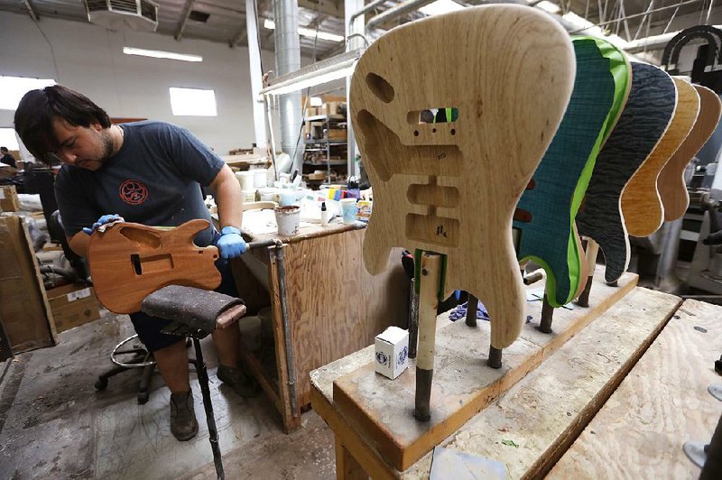 Hunter Martin, a lead stainer at Anderson Guitarworks, stains a Cobra guitar at the company’s headquarters in Newbury Park, Calif. 